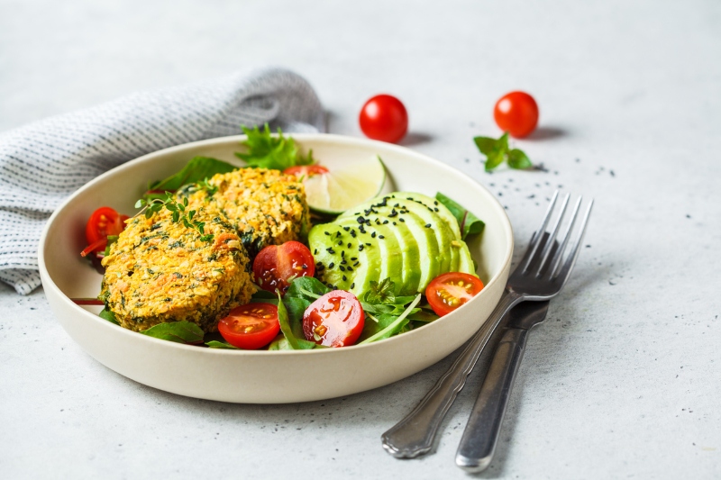 Vegan vegetable burgers with salad in a white plate, copy space.